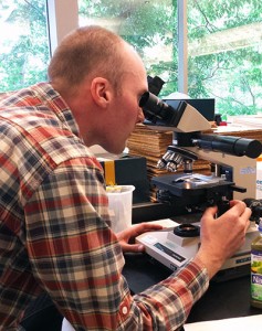 Robin Sleith uses a compound microscope to look for algae in Naked “Green Machine” juice.