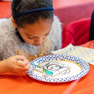 Photo of a child painting a tile