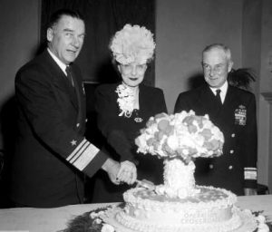 Operation Crossroads commanding officer Vice Admiral William Blandy and his wife slice into an Operation Crossroads cake following the first Bikini Atoll nuclear tests in 1946.