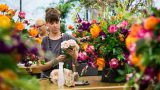 Photo of a woman creating a bouquet in a Floral Design class