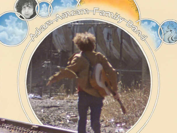 An album cover depicting a person with a guitar running along railroad tracks