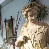 A marble statue stands in a garden room.
