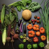 An arrangement of fresh vegetables on a black surface