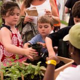 young boy and girl potting up a plant