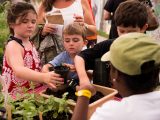 young boy and girl potting up a plant