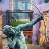 oxidized bronze sculpture of a man shooting with a bow