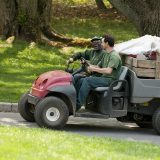Two workers driving through the gardens