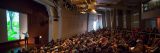 A filled-out Ross Lecture Hall during a presentation.