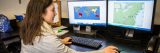 Scientist working at comptuers with maps