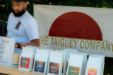A farm stand labeled "The Taiguey Company" offering bagged coffee beans