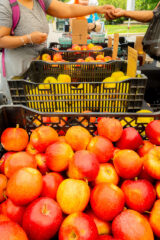 Large black baskets full of red and green apples