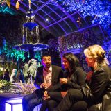 Two women and a man in the colorfully-lit Young Garden Circle Lounge.