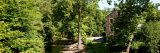 Stone Mill with the Bronx River with green grass and trees