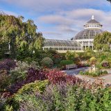 Conservatory behind fall flowers of the Perennial Garen