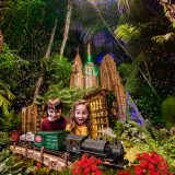 Two kids looking at a model train during the Holiday Train Show in the Conservatory
