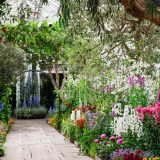 The path leading visitors through the exhibition is lined with pink, white, and yellow flowers.