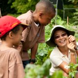 An NYBG staff member teaching two children about plants.