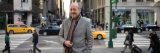 NYBG poet laureate Billy Collins standing on a busy New York City street.