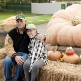 Photo of a man and a child next to a giant pumpkin