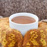 Mittens holding hot cocoa.