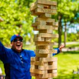 man in blue shirt playing a game of jenga