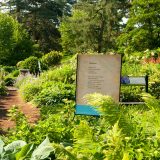 A sign in a garden displaying a poem