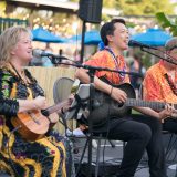 A group of musicians singing and playing the guitar