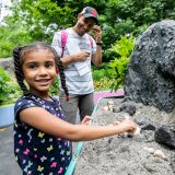 A girl playing in the sand table at the Adventure Garden.