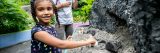 A girl playing in the sand table at the Adventure Garden.