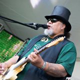 Willie K singing and playing a guitar