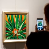 A visitor taking a photo of one of O'Keeffe's paintings.