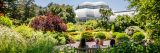 People sitting on a bench in front of the Perennial Garden in summer.