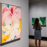 Woman looking at a few of Georgia O’Keeffe’s works on display in the LuEsther T. Mertz Library Art Gallery.