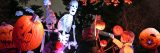 A life-size skeleton puppet surrounded by several children wearing puffy jackets during the night