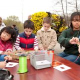 Kids sitting at a table decorating bags