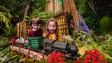 Two kids looking at a model train during the Holiday Train Show in the Conservatory