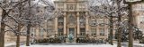 The facade of the Mertz Library in winter with snow-covered trees surrounding it.