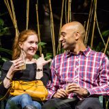 A couple sitting and holding drinks in the Consevatory.