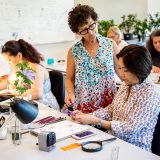 Woman teaching other woman with colored pencils in botanical illustration