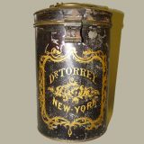 a dark brown cyclindrical container with the words Dr. Torrey New York in yellow