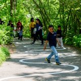 Children and parents following a winding path in the Everett Children's Adventure Garden.