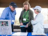 Three people looking at an ipad