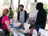 people talking over a table of material during citizen science weekend