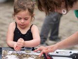 young girl sorting seeds on a table