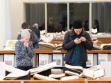 two people looking at open displayed books in the library