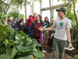 Tour guide showing people around the inside of the Conservatory