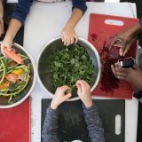 An overhead shot of people working with vegetables.