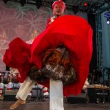 A woman in a flowing red dress dancing.