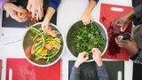 An overhead shot of people working with vegetables.