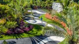 An aerial view of Brazilian Modern, showing palms, a black and white patterned pathway, and native Brazilian plants.